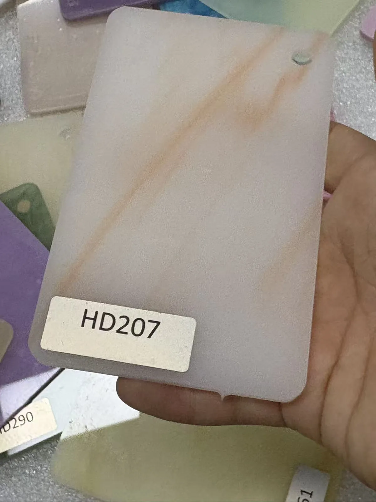 White marble-effect acrylic swatch with orange veining